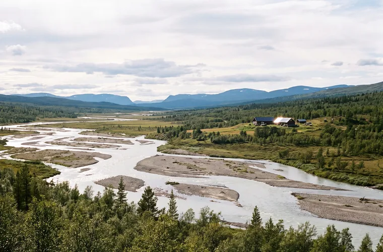 Västerbottniskt landskap med älvdal, tajga och en gård med solceller på taket